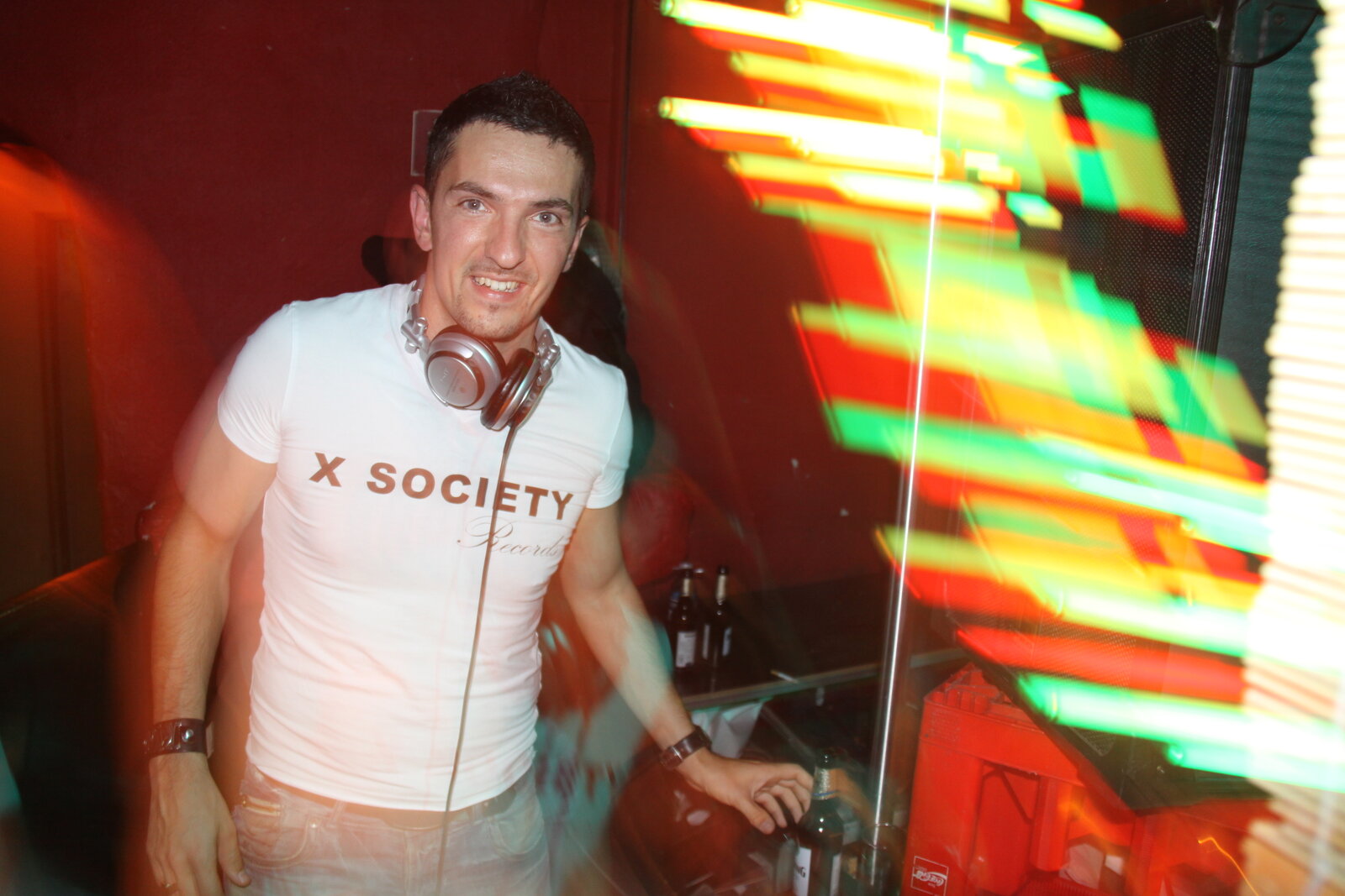 DJ Monaco en booth devant un mur LED avec équaliseur coloré