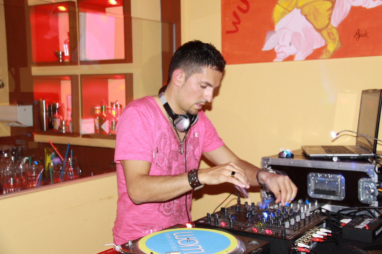 DJ Monaco en t-shirt rose mixant sur platines vinyle en lounge